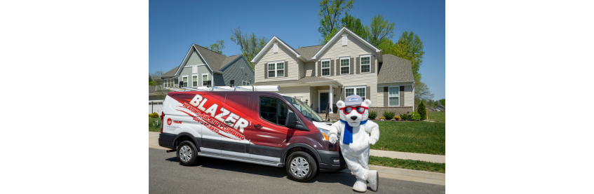 Blaze the Bear with plumbing truck in front of home